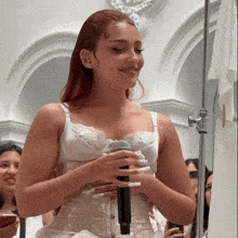 a woman in a white corset holding a microphone