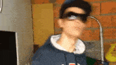 a young man wearing sunglasses and a hoodie is standing in a room .