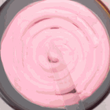 a pink cake is being decorated with chocolate drips