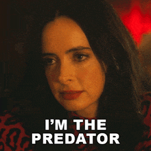 a close up of a woman 's face with the words i 'm the predator behind her