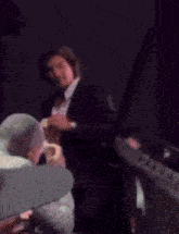 a man in a suit is taking a picture of another man in a theatre .