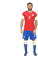 a man with a beard wearing a red shirt and blue shorts with the number 2 on them .