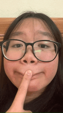 a woman wearing glasses is making a funny face