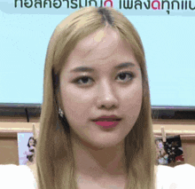 a close up of a woman 's face with a sign in the background that says ' a ' on it