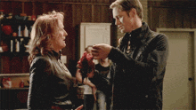 a man is holding a piece of bloody meat in front of an older woman