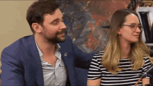 a man and a woman are sitting next to each other .