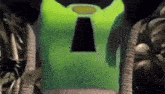 a green shirt with a hole in the middle of it is being worn by a person .