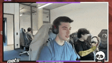 a man wearing headphones sits in a chair in front of a screen that says nats on it