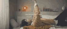 a man is laying on a bed with his arms outstretched and the words yearning to be with you again on the bottom .