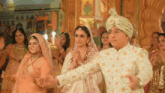 a bride and groom are dancing in front of a crowd at a wedding reception .