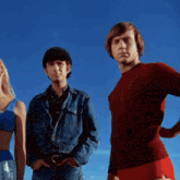 a man in a red shirt is standing next to a woman in a blue top