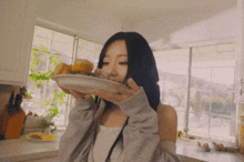 a woman is eating a hamburger from a white plate