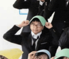 a group of people are posing for a picture and one of them is wearing a green hat