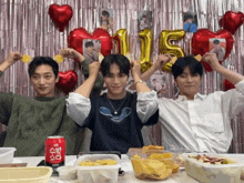 a group of young men are posing for a picture in front of balloons and a can of zero