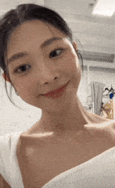 a woman in a white dress looks at the camera