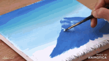 a person is painting a picture of a mountain on a canvas with the words made in animatica on the bottom