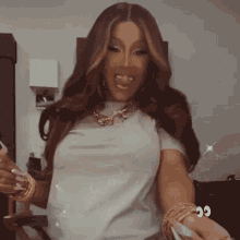 a woman is wearing a white shirt and a gold necklace