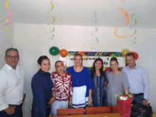a group of people are posing for a picture in front of a sign that says happy day
