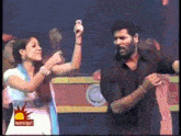 a man and a woman are dancing on a stage in front of a sign that says ' sunrise '