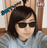 a woman wearing sunglasses has the word sorry written on her head