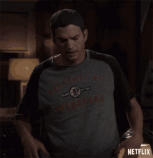 a man wearing a property of predators shirt