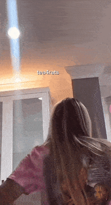 a woman in a pink tie dye shirt with tea4rats written on the bottom of the screen