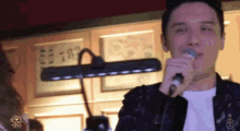 a man singing into a microphone in front of a sign that says 18