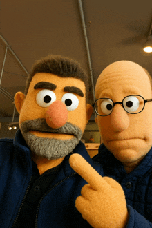 two sesame street puppets are posing for a picture together