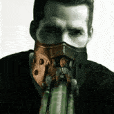 a man with a mask on his face is holding something in his hand