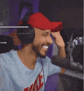 a man wearing headphones and a red hat is giving a high five to someone .
