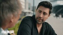 a man talking to another man with #kalpazan on the bottom right