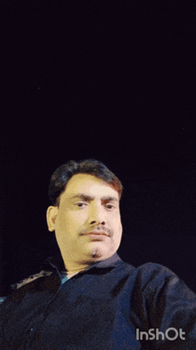 a man in a black shirt is standing in front of a group of people in a room that says inshot on the bottom