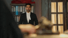 a man in a suit and tie is standing in a room in front of a judge 's gavel .