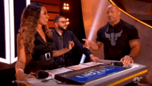 a man and a woman are sitting at a table with a sign that says titan .