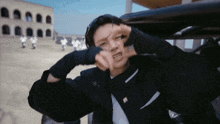 a man in a suit is making a funny face in front of a group of people