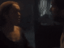 a close up of a person 's arm in a dark room with a black background .