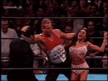 a man and a woman are wrestling in a ring .