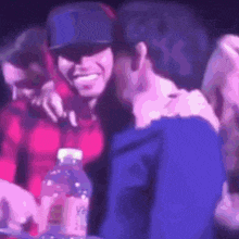 a man in a blue jacket is hugging a woman in a red shirt
