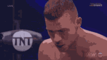 a tnt logo can be seen behind a man 's head