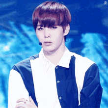 a young man with red hair is wearing a blue and white shirt and a microphone