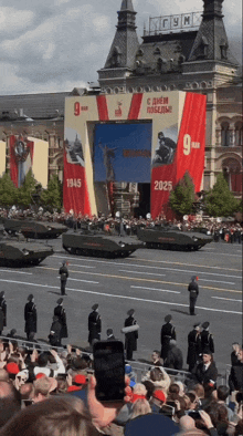 a crowd of people are gathered in front of a large sign that says 1945 2025