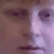 a close up of a person 's face with purple eyes and a purple background .