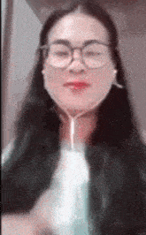 a woman wearing glasses and ear buds is looking at the camera .
