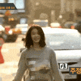 a woman is walking down a street wearing a sweatshirt that says surf on it .
