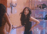 a woman in a black dress is standing next to another woman