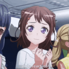 a girl with purple eyes is making a viole reaction gesture while sitting next to two other girls .