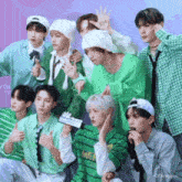 a group of young men are posing for a picture and one of them is wearing a green shirt .