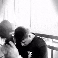 a black and white photo of a man holding a woman 's head .