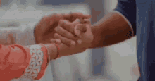 a man and woman are holding hands in a close up of their hands .