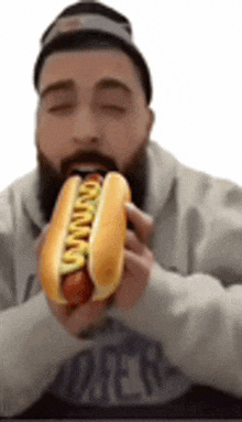 a man is eating a hot dog with mustard on it .